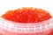 Red caviar in a plastic container on a white background. Caviar storage. Seafood. Expensive food