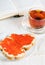 Red caviar on a slice of bread, tea and open book