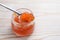 Red caviar on a spoon and in a glass on a white painted wooden table, festive seafood snack for holidays, copy space