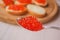 Red caviar in a spoon on a light background, selective focus. Gourmet food. Making sandwiches