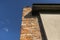 A red ceramic brick chimney standing at the rear of the building, by the facade, with a blue sky in the background.