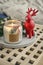 Red ceramic deer and candle in jar with fir tree branches