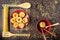 A red ceramic plate with dry fettuccine paste on a bamboo napkin and a red bowl with paste and bamboo spoons on a dark wooden