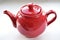 Red ceramic teapot on white background