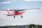 Red Cessna 150 takes off from the runway