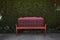 Red chair in front of leaf wall