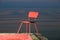 Red chair on a lagoon background. Lithuania, Nida