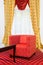 Red chair in the room with vintage red carpet and classic yellow drapes