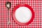 Red checked table cloth with plate and spoon