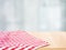 Red checked tablecloth on wood with blur home window background