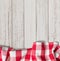 Red checkered picnic tablecloth on white wood table