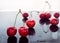 Red cherries are reflected against a black mirror background