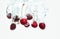 Red Cherries splashing into water against white background