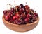 Red cherries in a wooden bowl on a white