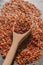 Red chili flakes. Close up view of heap of chili flakes on wooden spoon. Red cayenne pepper background.