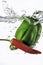 Red Chili and green pepper dropped into water