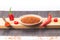 Red chili pepper sliced and Chilli powder scattered â€‹â€‹on wooden base on white background. .Gastronomy and cooking condiments