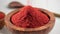 Red chili powder or paprika in a wooden bowl rotation