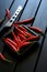 Red chilli pods and a vegetable and cheese knife lie on a black wooden surface. Daylight