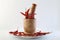 Red chillies with mortar and pestle on white background