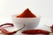 Red chillies with red chilly powder on white background