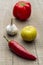 Red chilly, lemon, garlic and a capsicum in a wooden background