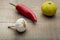 Red chilly, lemon and garlic in a wooden background