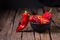 Red chilly pepper on wooden black background. Red hot chili peppers.