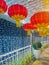 Red Chinese lanterns hang on a terrace decorated with luminous garlands for Chinese New Year.