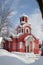 Red Christian church in the winter, snow on the roof