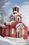 Red Christian church in the winter, snow on the roof