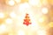 Red christma tree outline on yellow, gold, and white color bokeh background.