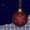 A red Christmas ball with a snowflake hangs on a dark blue background.