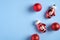 Red Christmas balls and Santa gloves decorations on blue background. Flat lay, top view, copy space