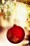 Red Christmas bauble on christmas tree on shine light background, close up