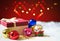 Red Christmas gift box and bokhe on background of defocused colo