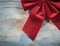 Red Christmas knot on wooden board top view celebrations concept