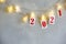 Red christmas numbers 2021 on garland. New Year`s lights in transparent clothespins. Gray background. Holiday decoration or