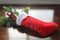 Red Christmas stocking filled with pine and berries in the sunlight