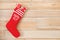 Red Christmas stocking full of gifts hanging on wooden wall, space for text.