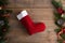 Red Christmas stockings on a rustic wooden wall background with Christmas decoration, fir tree and cone