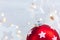 Red christmas tree ball on blurred garland lights background