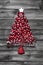 Red christmas tree with balls on old wooden shabby background.