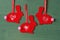 Red Christmas tree decoration in the shape of a rabbit made of felt with ornaments on a green background