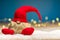 Red christmas wretch sitting on snow in front of bokeh lights an