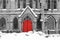 Red church door in snowy black and white winter street scene on 4th Avenue in the East Village of New York City