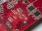 Red circuit board with chips and capacitors. Electronic board close-up