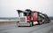 Red classic big rig semi truck with car hauler trailer running b