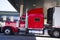 Red classic big rig semi truck and reefer trailer