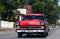 A red classic car drived on the street in havana city